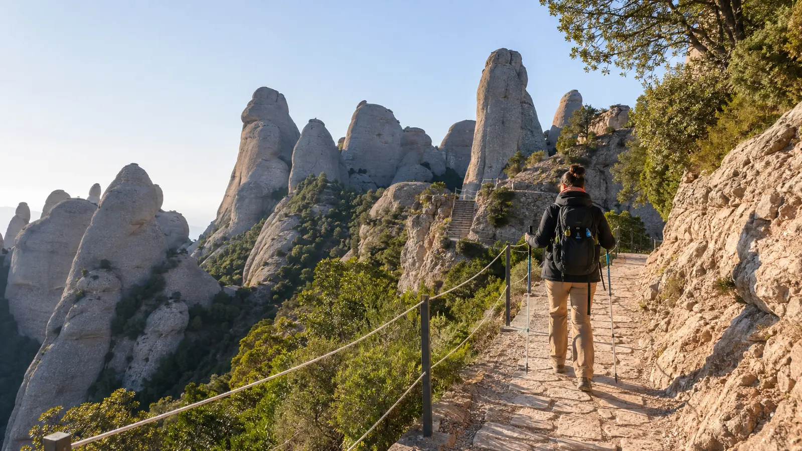 Hiker following the Montserrat Sant Jeroni trail beneath the sawtooth rock towers